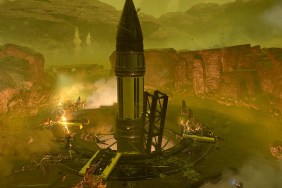 Helldivers 2: a giant rocket in the center of a battle between soldiers and large creatures.